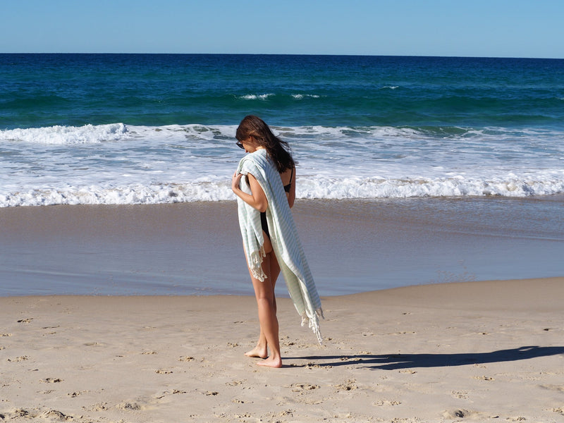 woman on beach with PORTSEA TURKISH COTTON TOWEL - SEAFOAM